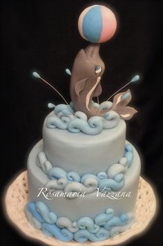 a blue and white cake with a dolphin on top