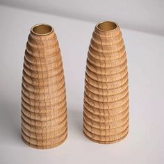 two wooden vases sitting next to each other on a white surface with no one around them