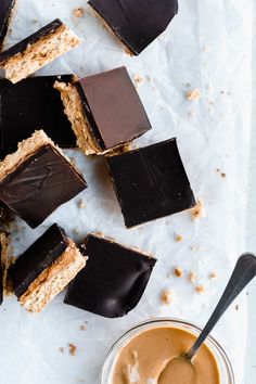 there are many pieces of chocolate on top of each other with a spoon next to it