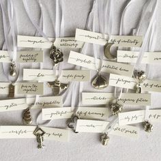 several pieces of jewelry are on display with name tags attached to the strings that hang from them