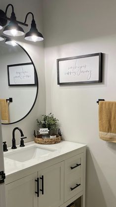 a bathroom with a sink, mirror and towel rack on the wall next to it