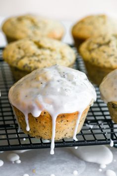 there are muffins with icing on the cooling rack