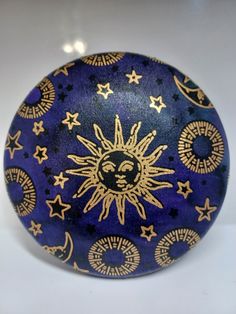 a blue and gold painted ball with stars on it