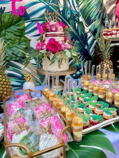 a table with pineapples, cupcakes and other desserts on it