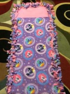 a purple dress with pink ruffles and an image of princess ponies on it