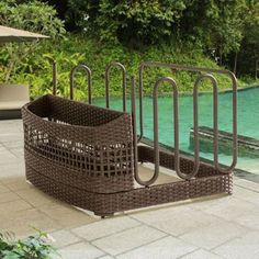 an outdoor swimming pool with brown wicker furniture