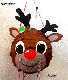 a reindeer pinata hanging from a string on the wall with red nose and antlers