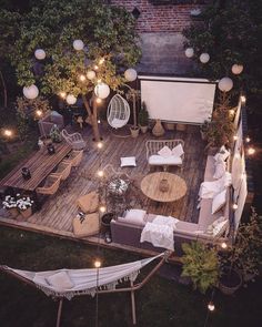 an overhead view of a backyard with lights and furniture on the deck, surrounded by greenery