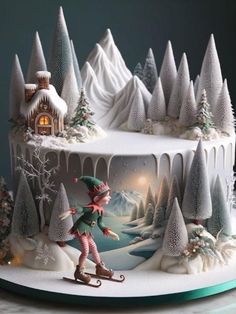 a christmas cake decorated with an elf skiing in front of a snow covered mountain and forest scene