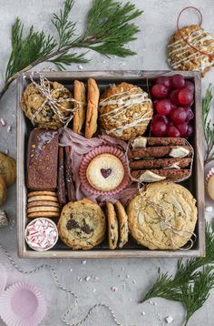 a box filled with cookies and pastries on top of a table next to christmas decorations