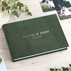 a personalized wedding album on a table with photos and greenery in the background