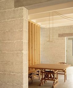 a table and chairs in a room with exposed brick walls on either side of it