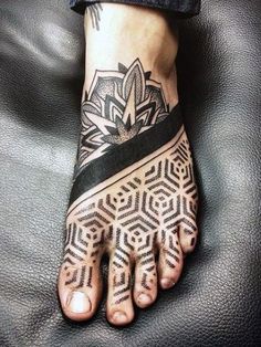 a person's foot with tattoos on it and an intricate design in the middle