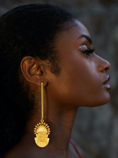 Toronto-based Symbols of Authority specializes in everyday statement jewelry. Inspired by the 16th-century Bini Queen Idia, renowned for her bravery, the Adunni x Idia Bar Earrings boast a shoulder-sweeping bar design. They are handmade from micron-plated brass and etched with the iconic Iyoba ivory mask. Make them the focal point by keeping your other jewelry pieces simple.- Butterfly fastening- Brass, micron-plated gold- Handcrafted by expert artisans using ethically and sustainably sourced materials- Made in Jaipur, India, ships from Canada Ghanaian Gold Jewelry, Yellow Gold Spiritual Earrings, Temple Jewelry Style Drop Plug Earrings, Ceremonial Drop Earrings, Gold Fusion Long Drop Earrings, Fusion Style Hand Forged Drop Earrings, Hand Forged Gold Earrings, Spiritual Hand Forged Dangle Earrings, Spiritual Hand-forged Dangle Earrings