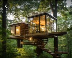 a tree house in the middle of a forest with stairs leading up to it's second floor