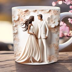 a paper cut out of a bride and groom on a coffee mug with flowers in the background