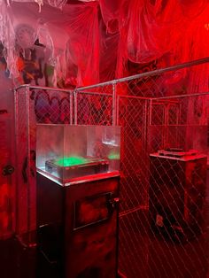 a room with red lights and plastic curtains on the walls, including a neon green light