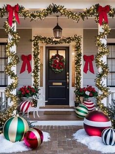 christmas decorations on the front porch of a house with lights and wreaths around them