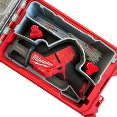 a red tool box filled with tools on top of a white surface