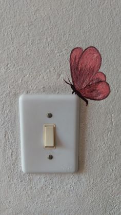 a white light switch with a red butterfly on it's back side and a pink flower attached to the wall