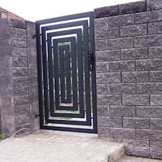 an open gate in the side of a brick wall