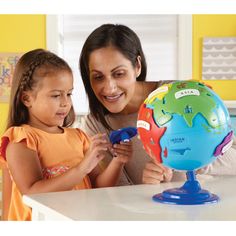 a mother and daughter playing with a globe