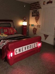 a bedroom decorated in red and grey with the name chevrolet written on the bed frame