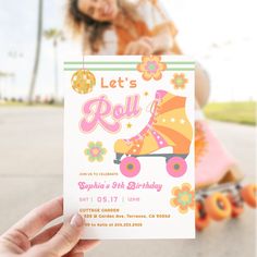 a person holding up a birthday card in front of a skateboard with flowers on it