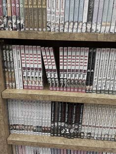 several rows of dvd's on wooden shelves in a library