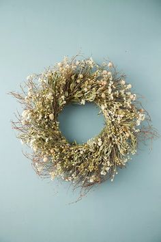 a dried wreath with white flowers on a blue background