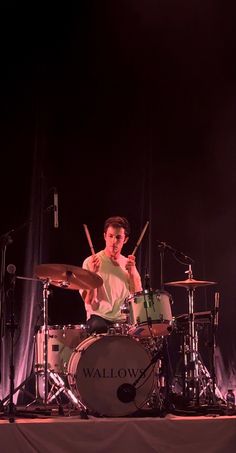 a man is playing drums on stage