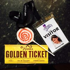 a ticket, lollipop stick and lanyard on a table