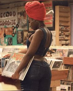 a woman is standing in a bookstore with headphones on and looking at the books