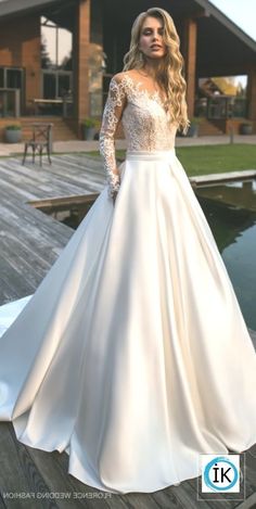 a woman in a white wedding dress standing on a dock with her hands on her hips