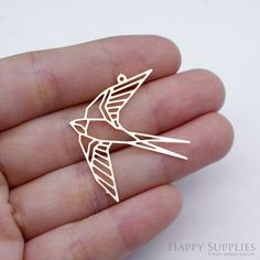 a small bird brooch pin sitting on top of someone's hand