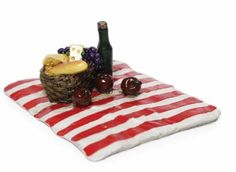 a picnic mat with wine, bread and grapes on it is shown in front of a white background