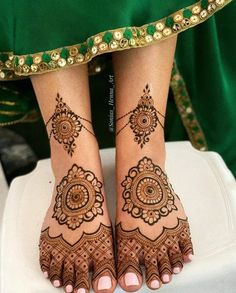 the legs and feet of a woman with henna tattoos