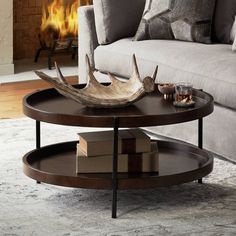 This contemporary coffee table emits a minimalist aesthetic while still being chic and functional. The design features ample space to display things above as well as store things below. A dark brown finish covers this coffee table that is constructed from wood materials. Modern Industrial Minimalist, Magic Cottage, Wood Round Coffee Table, Coffee Table Centerpiece, Coffee Table Style, Mango Wood Coffee Table, Wood Cocktail Table, Brown Leather Couch, Sitting Room Decor