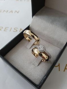 two gold rings sitting in a box on top of a table