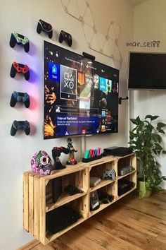 a flat screen tv mounted to the side of a wall next to a wooden shelf