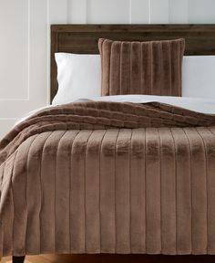 a bed with a brown comforter and pillows