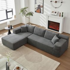 a living room with a large sectional couch and fireplace in the corner, along with a rug on the floor