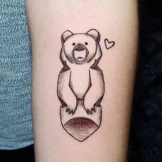 a bear tattoo on the arm with a heart