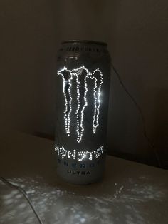 a can that has some kind of light up on top of it, with the words monster energy lit up in front of it