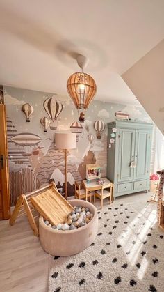 a child's bedroom with hot air balloons on the wall and toys in an ottoman