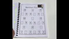 a hand holding a notebook with numbers on it