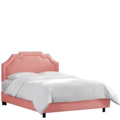 a bed with pink upholstered headboard and white sheets on the bottom side