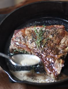 a piece of meat is being cooked in a skillet