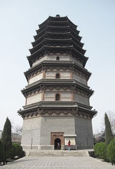 a tall tower with two people standing in front of it