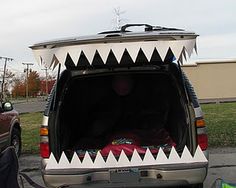 the back end of a van with a shark's teeth painted on it